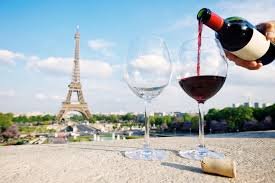 Two glasses of wine being served outdoors with a view of the Eiffel Tower.