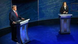 Kamala Harris and Donald Trump stand at podiums on a blue stage during the first presidential debate.